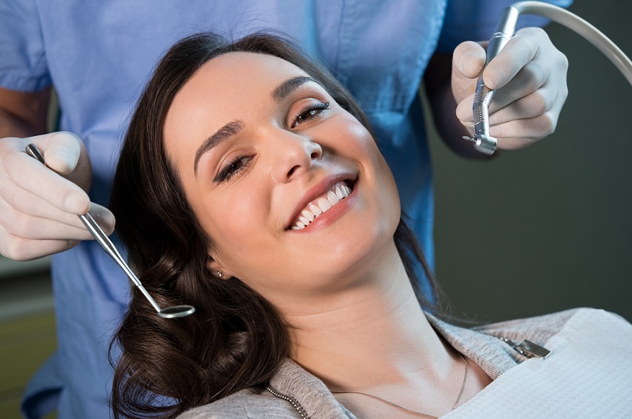 אישה צעירה מחייכת אחרי טיפול שיניים מוצלח